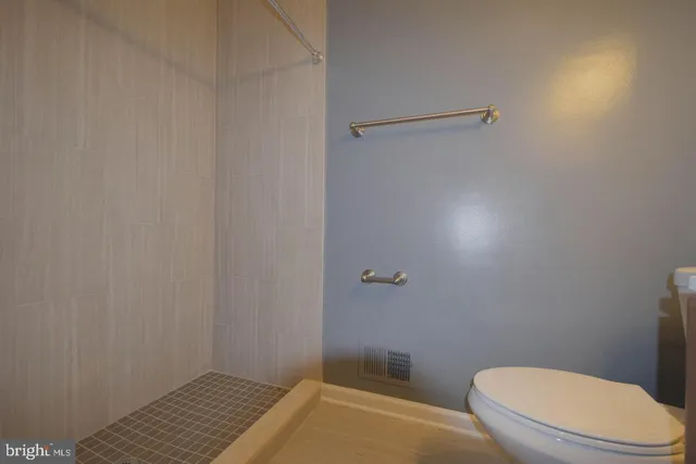 a bathroom with a toilet and a shower