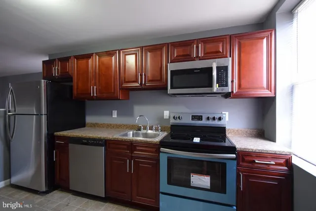 a kitchen with granite countertop a stove top oven microwave and cabinets