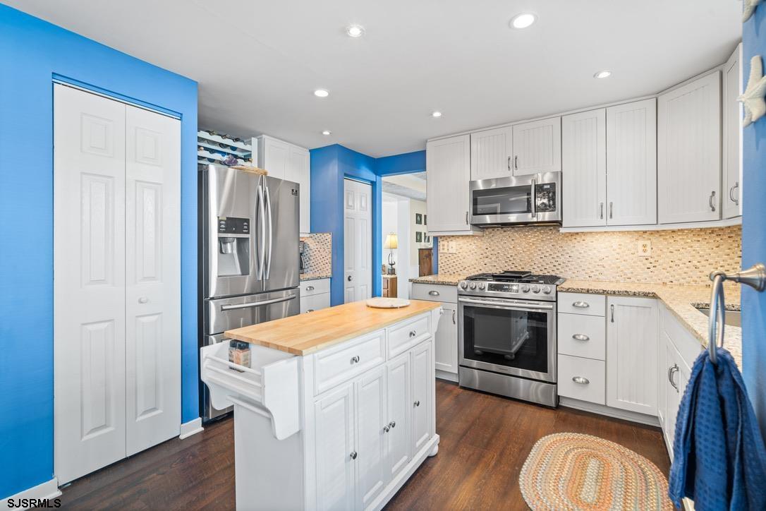 17 Manitoba Avenue Brigantine, NJ 08203 - Photo 12 of 49 a kitchen with stainless steel appliances white cabinets and wooden floor