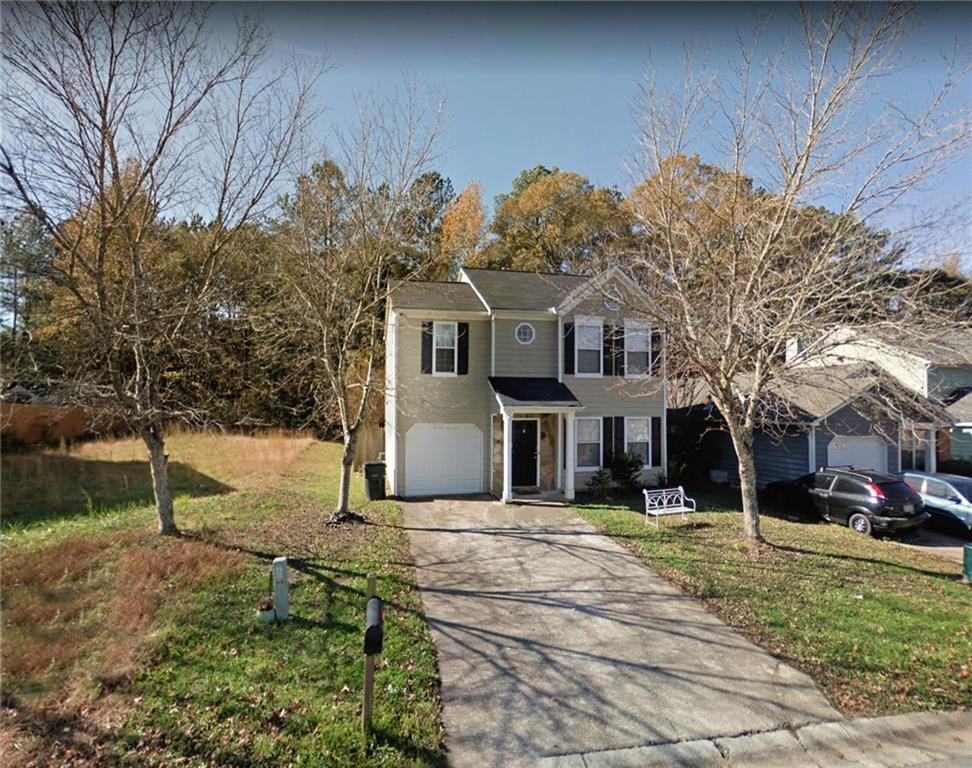 a front view of house with yard and trees around