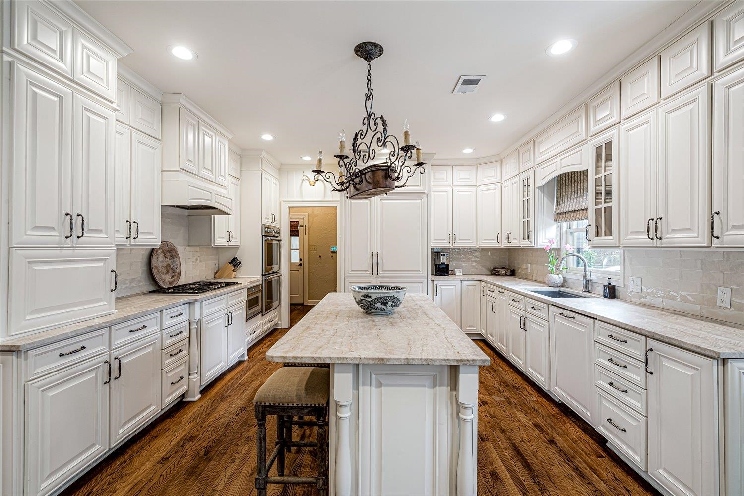 485 River Ridge Cove Memphis, TN 38120 - Photo 13 of 33 Kitchen with light stone counters, white cabinetry, backsplash, a center island, and a breakfast bar area