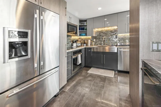 a kitchen with stainless steel appliances granite countertop a refrigerator and a stove
