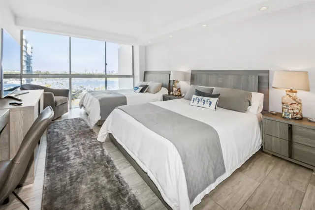 a bedroom with bed and large windows