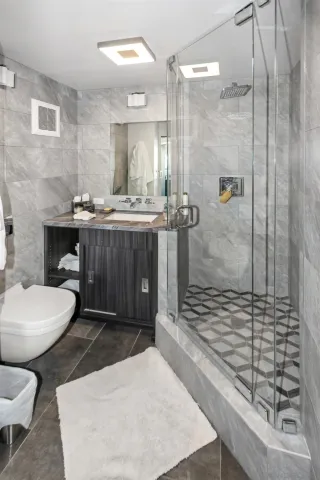 a bathroom with a sink a toilet a mirror and shower