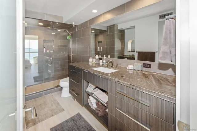 a bathroom with double vanity and a shower