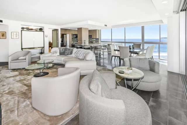 a living room with furniture and a view of kitchen