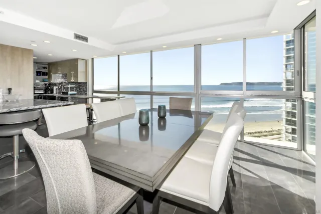 a dining room with furniture and large windows