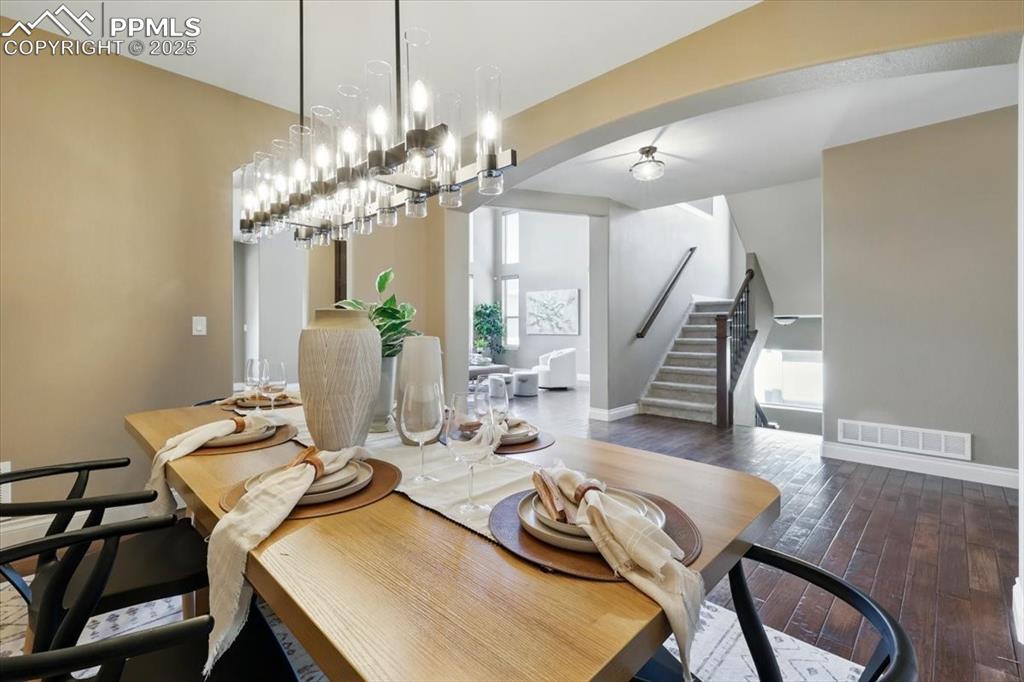 4577 Outlook Ridge Trail Colorado Springs, CO 80924 - Photo 12 of 45 a view of a dining room with furniture a chandelier and wooden floor