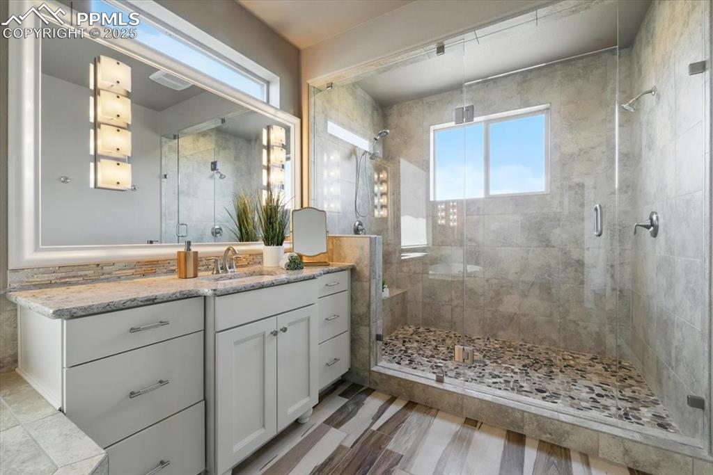 4577 Outlook Ridge Trail Colorado Springs, CO 80924 - Photo 23 of 45 a bathroom with a granite countertop sink a mirror and a shower