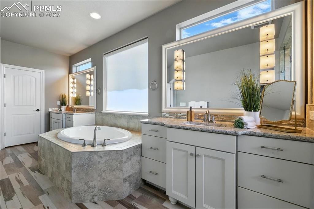 4577 Outlook Ridge Trail Colorado Springs, CO 80924 - Photo 25 of 45 a bathroom with a tub sink and mirror