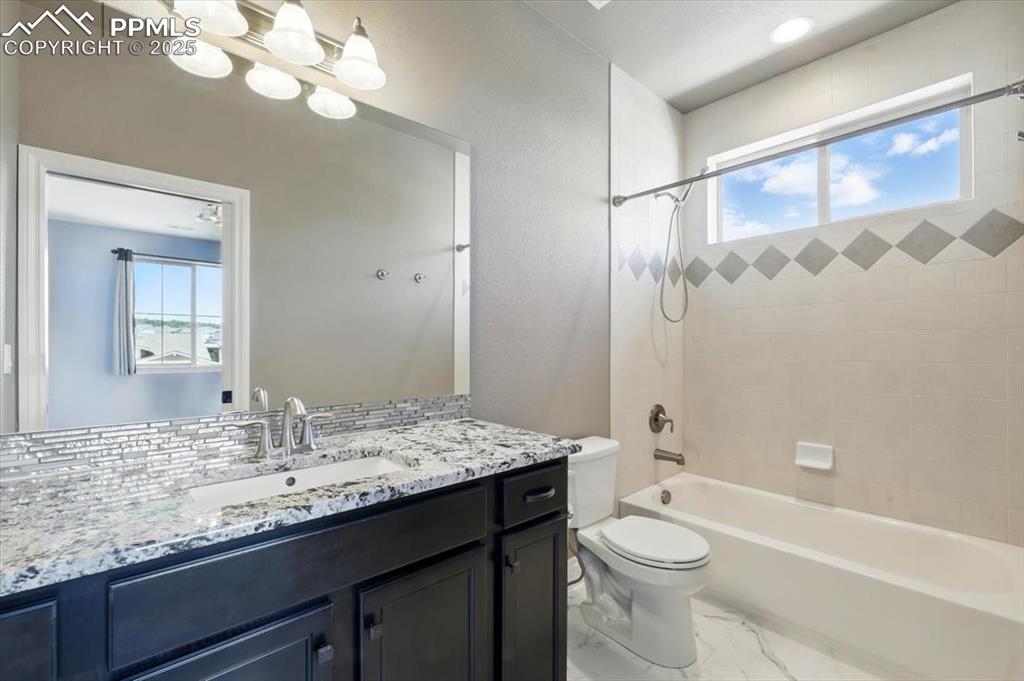 4577 Outlook Ridge Trail Colorado Springs, CO 80924 - Photo 32 of 45 a bathroom with a granite countertop sink a toilet and shower