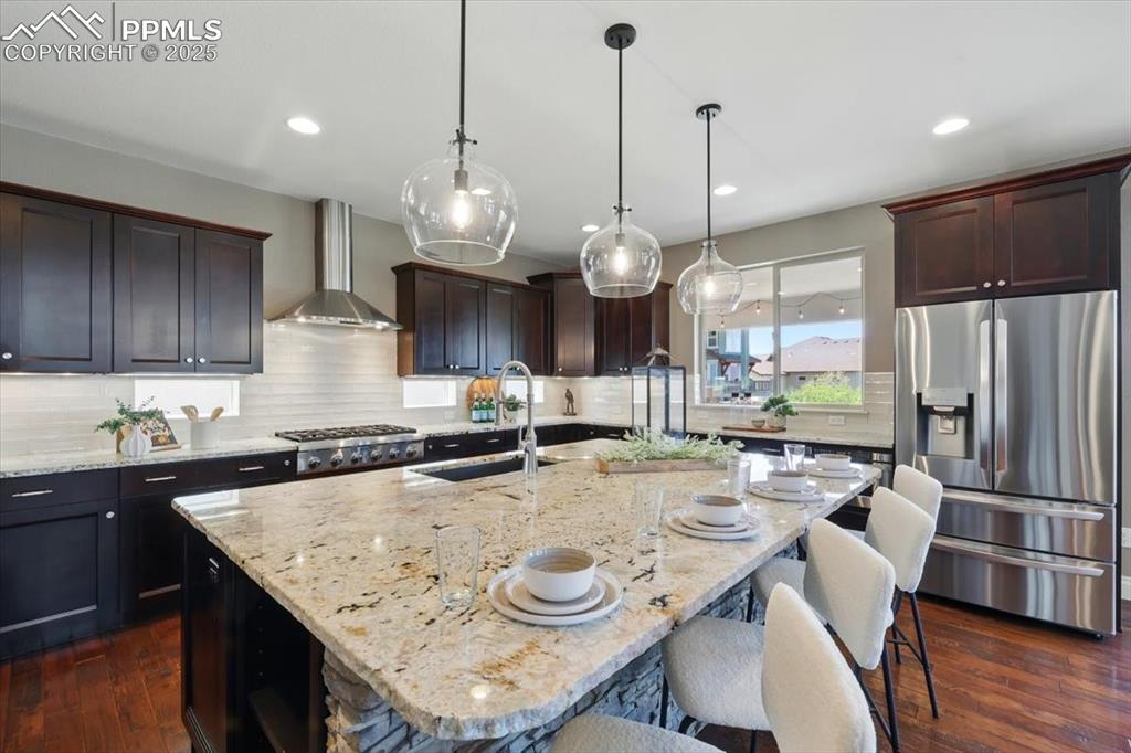 4577 Outlook Ridge Trail Colorado Springs, CO 80924 - Photo 7 of 45 a kitchen with stainless steel appliances granite countertop a sink a stove a refrigerator and chairs
