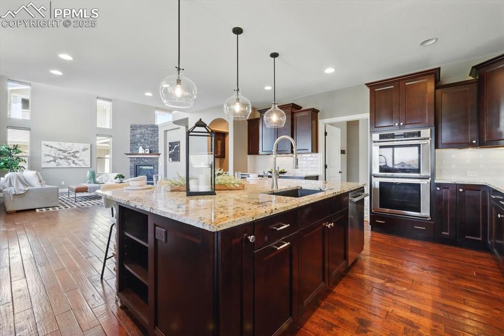 4577 Outlook Ridge Trail Colorado Springs, CO 80924 - Photo 8 of 45 a kitchen with stainless steel appliances kitchen island granite countertop a sink stove and refrigerator