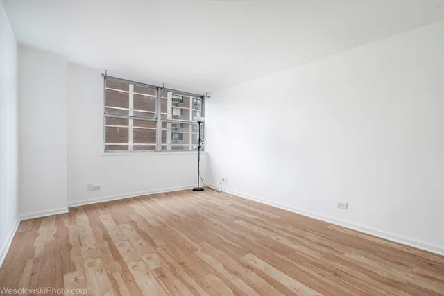 a view of a hallway with closet and a window