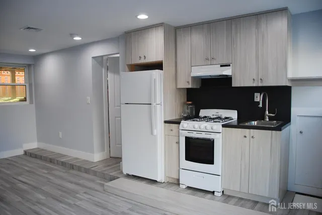 a kitchen with a refrigerator sink and cabinets