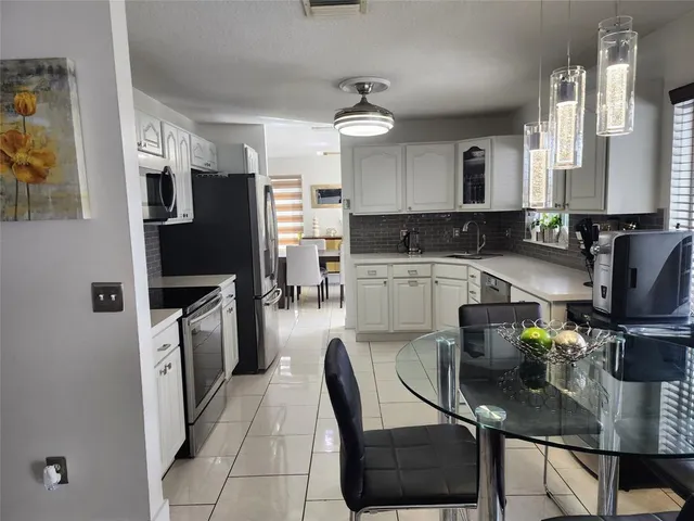a kitchen with stainless steel appliances granite countertop a sink refrigerator and cabinets