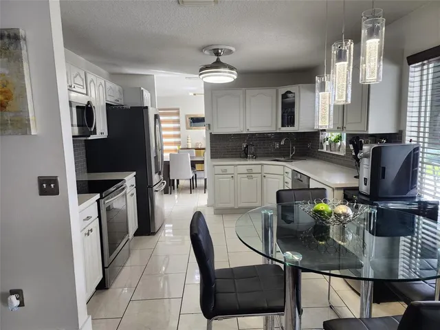 a kitchen with refrigerator and microwave