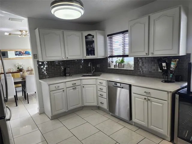 a kitchen with cabinets appliances and a window