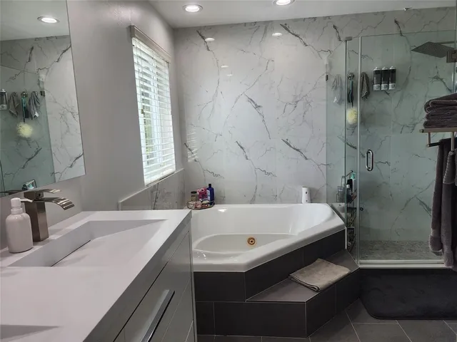 a bathroom with a tub sink and mirror