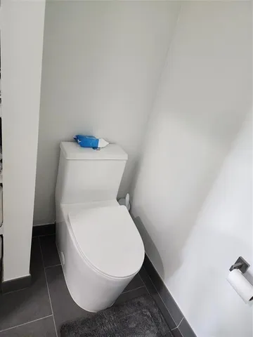 a white toilet sitting next to a white wall