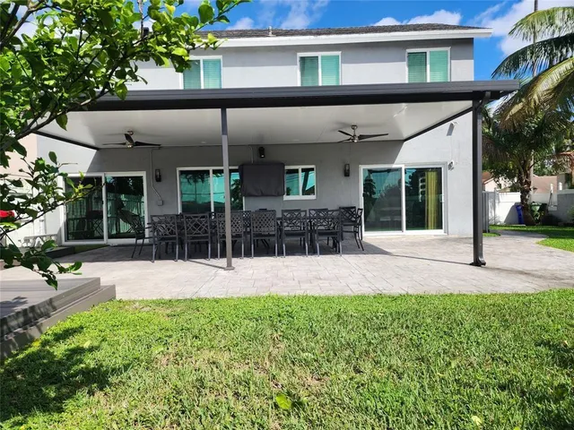 front view of a house with a yard and potted plants