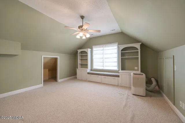 en empty room with windows and ceiling fan