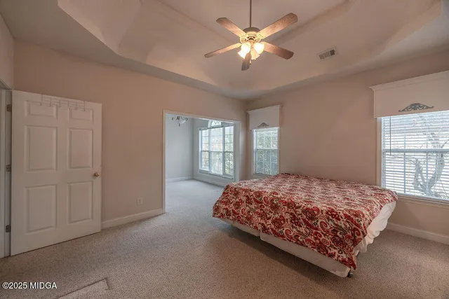 a bedroom with a bed chandelier and a window