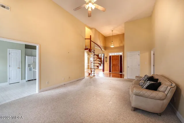 a view of a livingroom with furniture and a chandelier fan