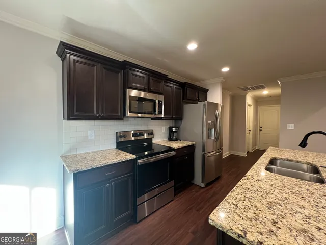 a kitchen with a sink stove and refrigerator