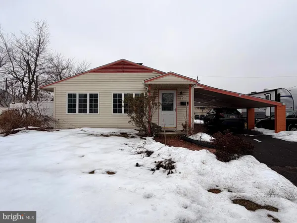 a front view of a house with a yard covered in snow