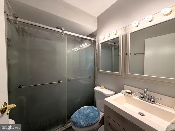 a bathroom with a sink toilet vanity and shower