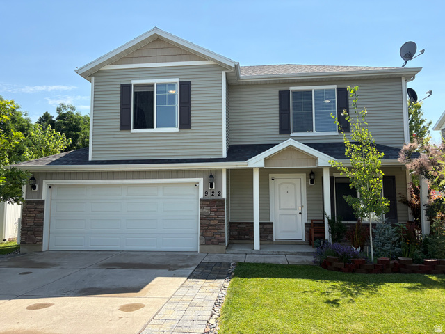 922 North 480 West Logan, UT 84321 - Photo 1 of 11 Two-story residence featuring light gray siding with dark brown shutters, a two-car garage, and a covered entry