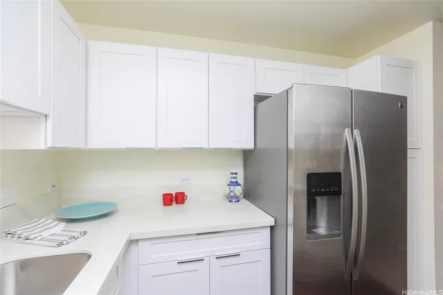 a kitchen with a sink a refrigerator and cabinets