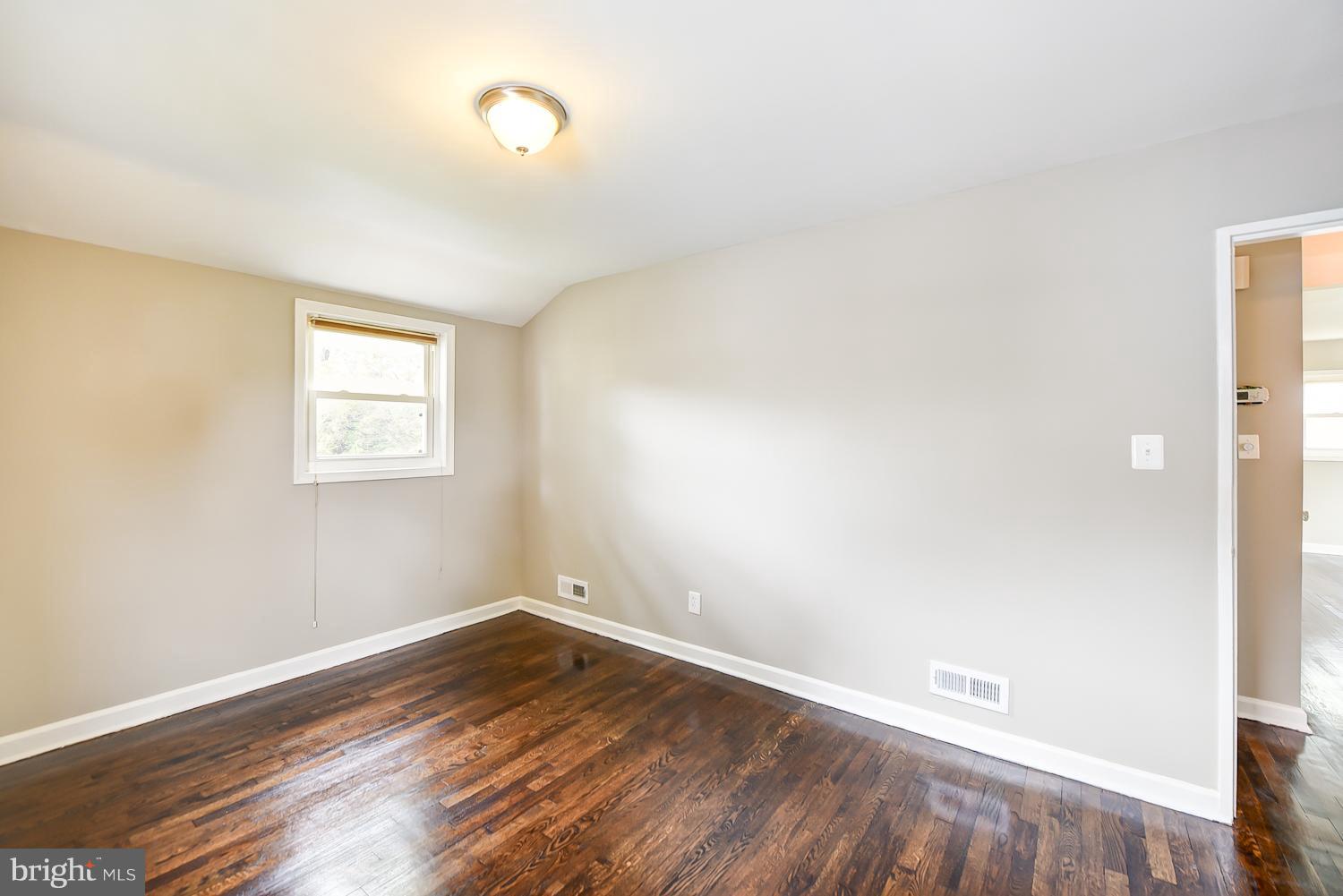 12816 Matey Road Silver Spring, MD 20906 - Photo 11 of 30 an empty room with wooden floor and windows