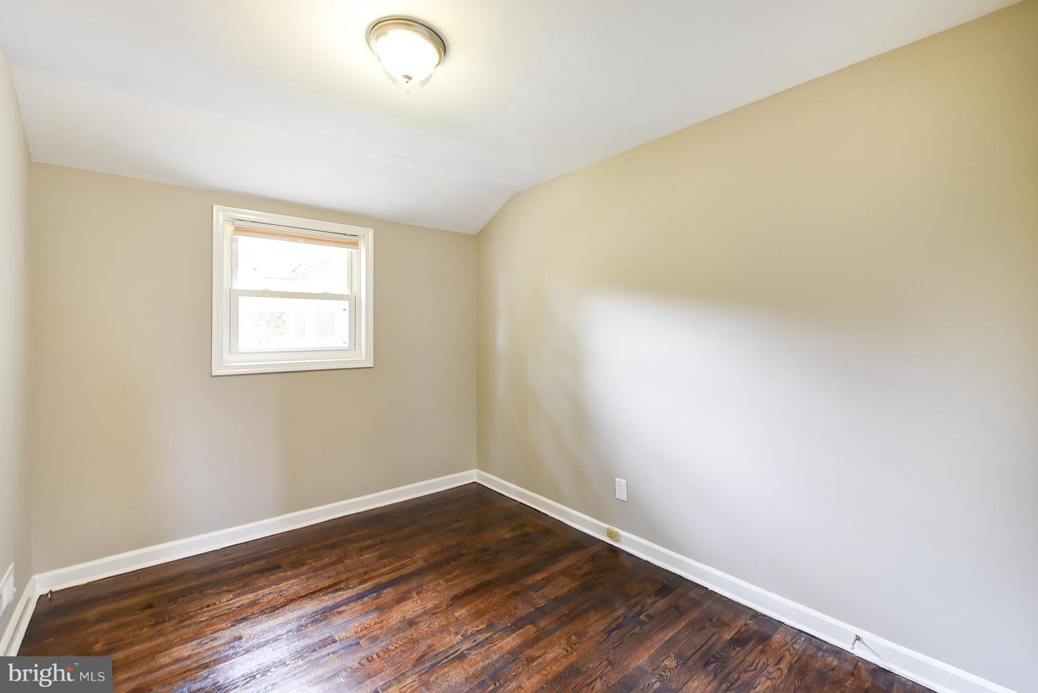 12816 Matey Road Silver Spring, MD 20906 - Photo 12 of 30 a view of an empty room with wooden floor and a window