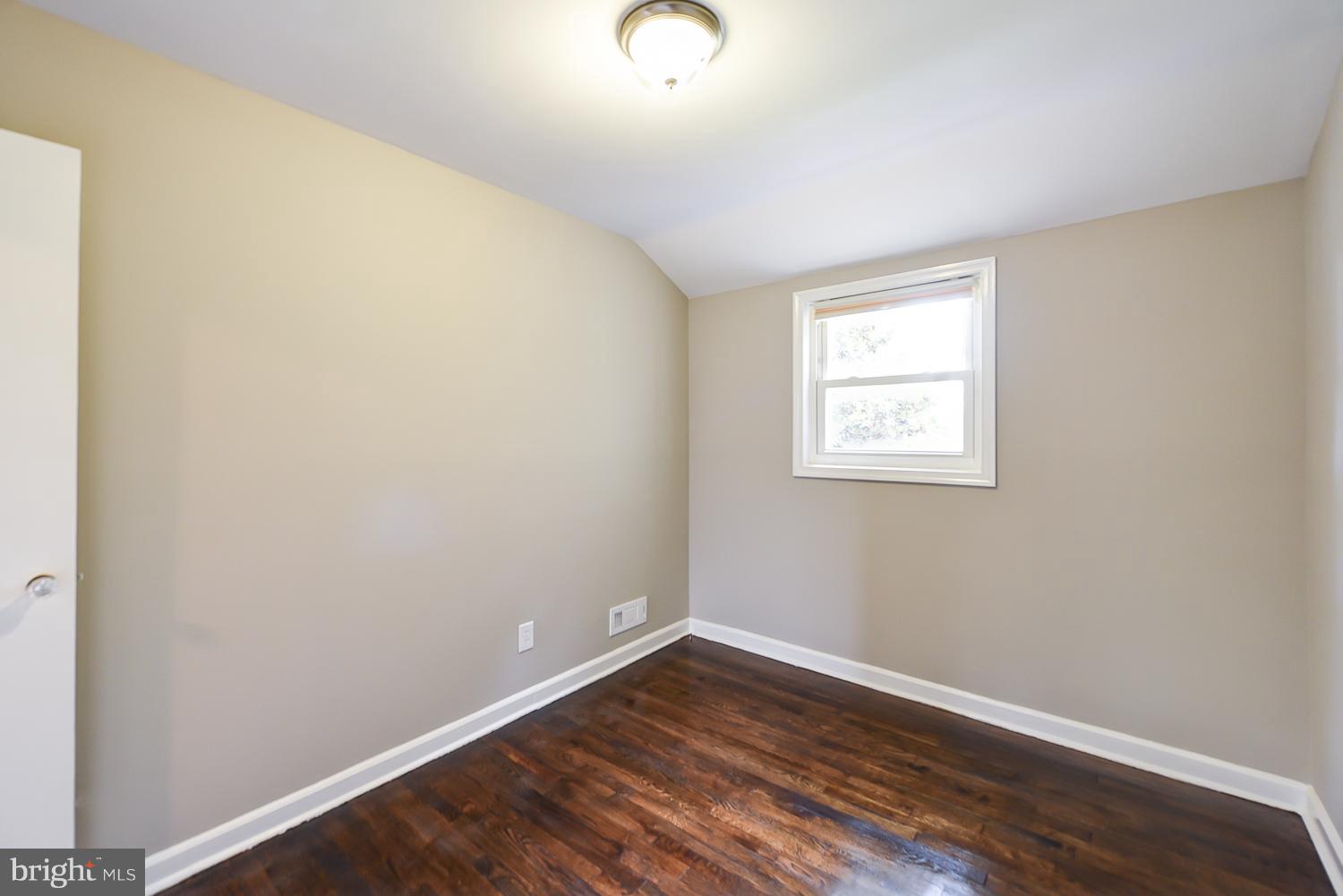 12816 Matey Road Silver Spring, MD 20906 - Photo 13 of 30 an empty room with wooden floor and windows