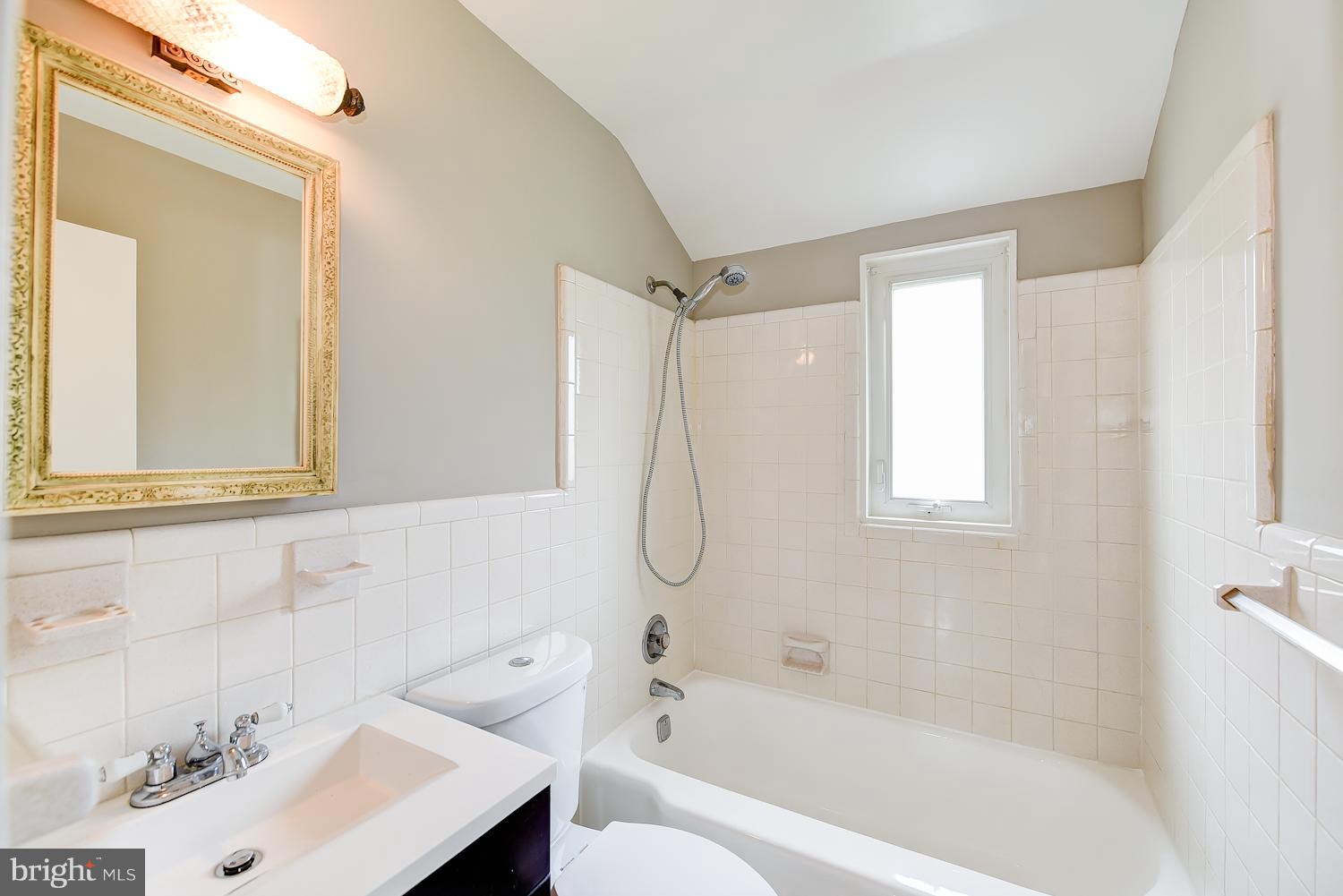 12816 Matey Road Silver Spring, MD 20906 - Photo 14 of 30 a bathroom with a bath tub a sink and a window