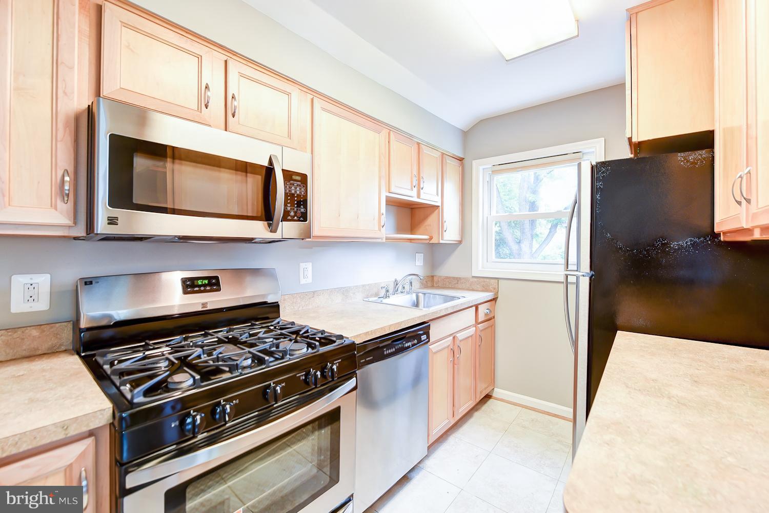 12816 Matey Road Silver Spring, MD 20906 - Photo 6 of 30 a kitchen with stainless steel appliances granite countertop a stove a microwave and a refrigerator