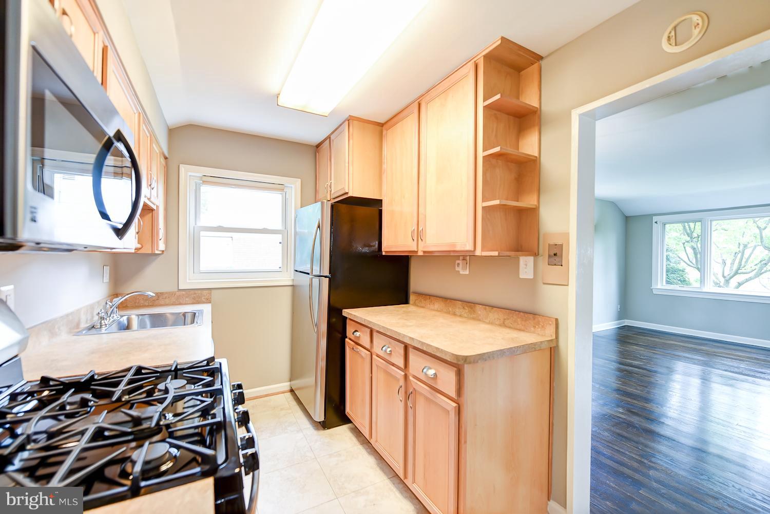 12816 Matey Road Silver Spring, MD 20906 - Photo 7 of 30 a kitchen with a stove a sink and a refrigerator