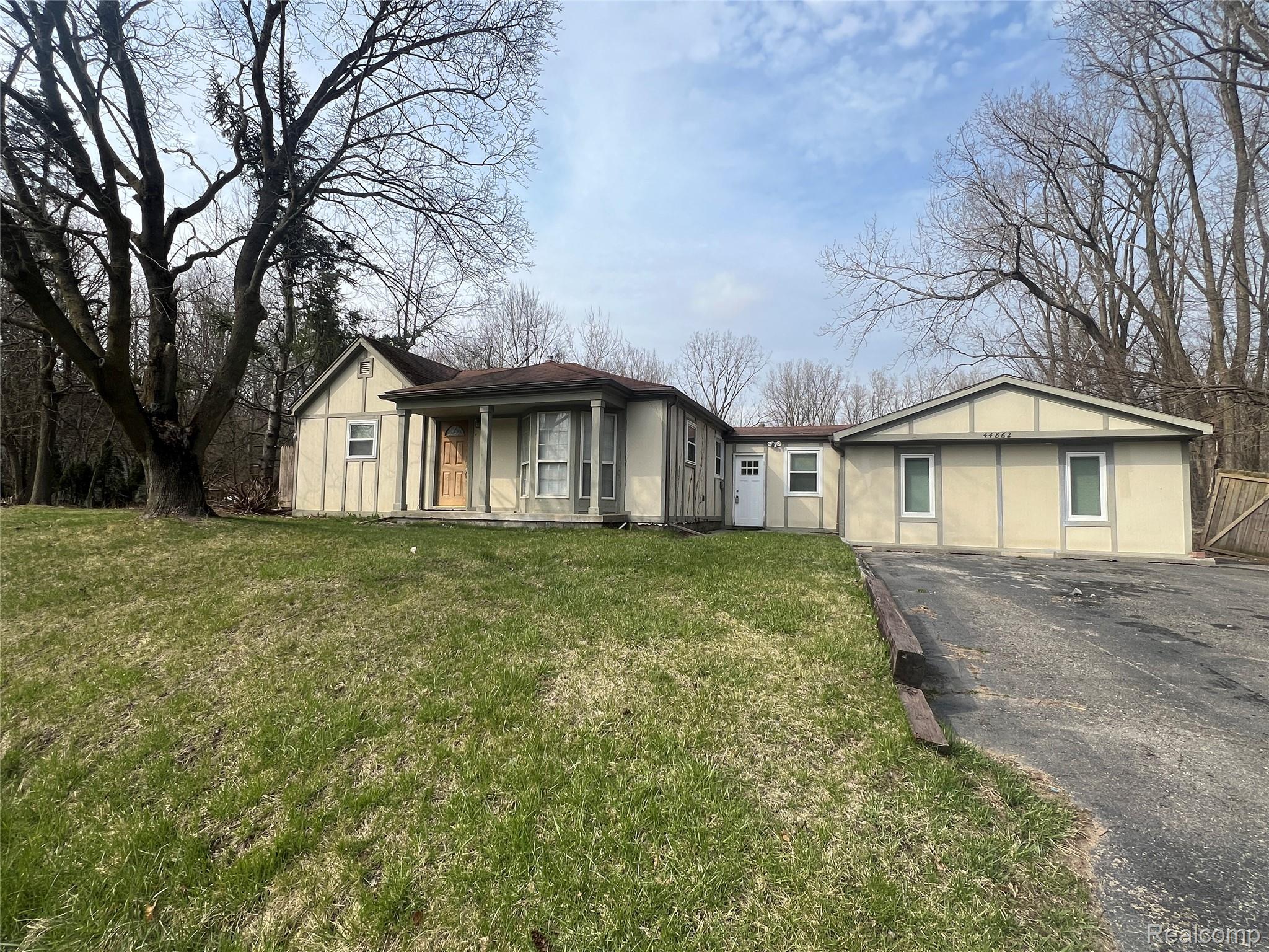Ranch-style house featuring driveway and a front yard