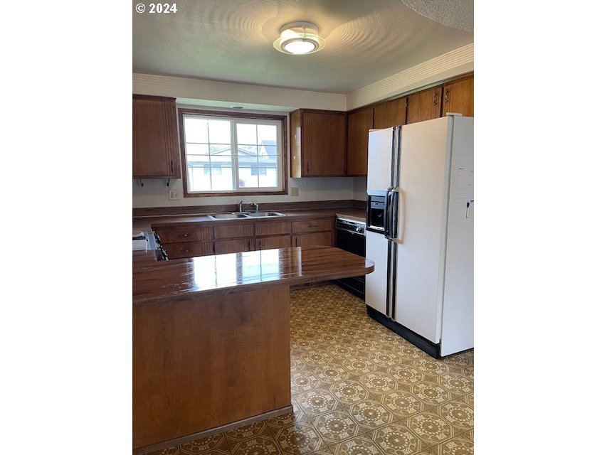 415 South 32nd Street Springfield, OR 97478 - Photo 3 of 10 a kitchen with granite countertop a refrigerator and a stove