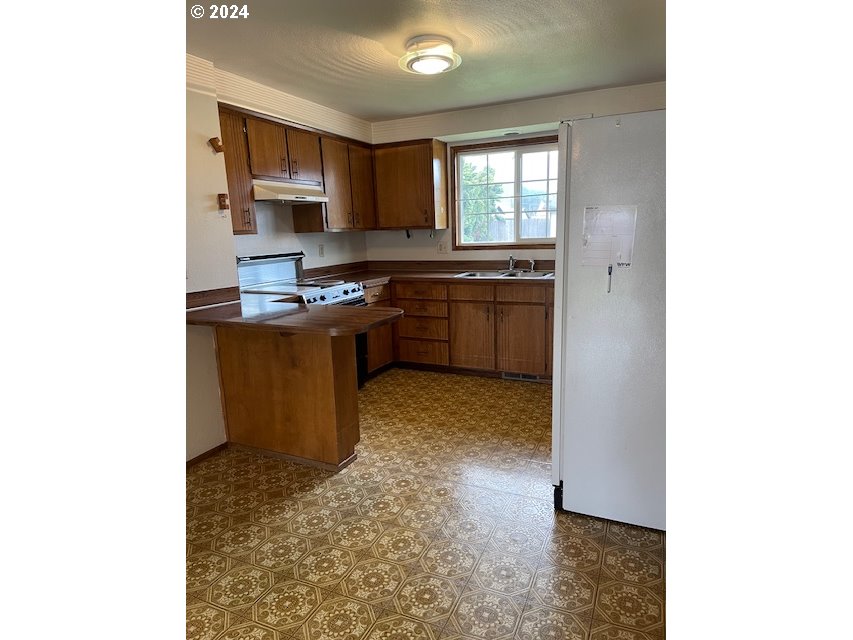 415 South 32nd Street Springfield, OR 97478 - Photo 4 of 10 a kitchen with stainless steel appliances granite countertop a sink stove and refrigerator