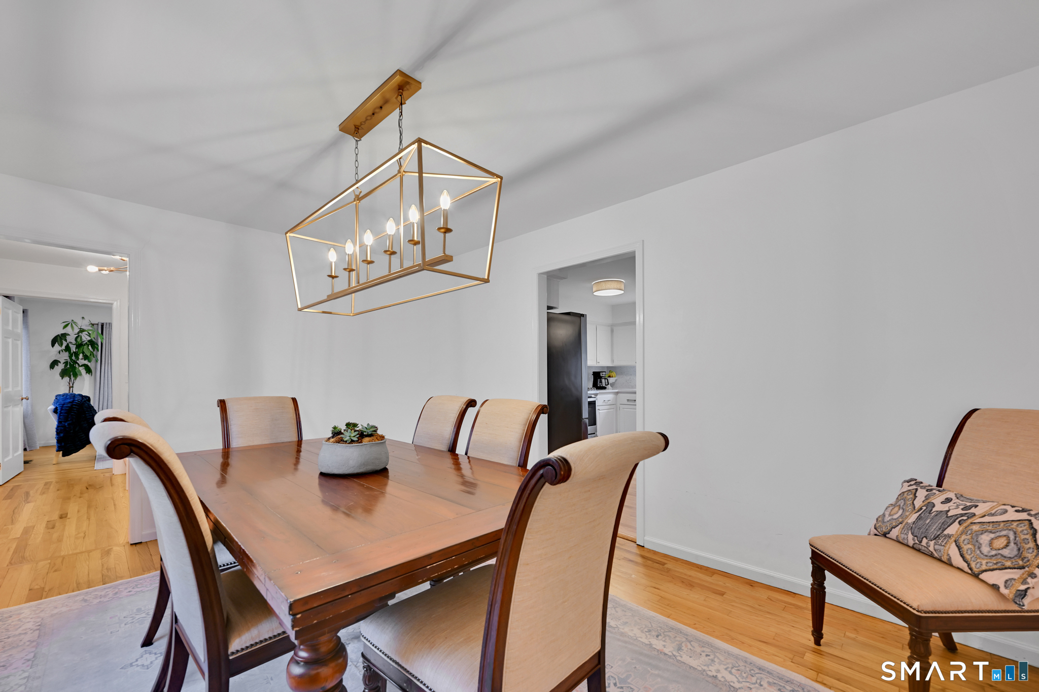 117 Settlers Farm Road Monroe, CT 06468 - Photo 7 of 40 A striking modern light fixture hangs gracefully from the ceiling , casting a welcoming glow, perfect for both casual meals and holiday gatherings.