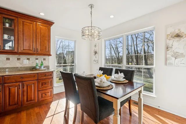 a kitchen with stainless steel appliances granite countertop a kitchen island a stove a table and chairs