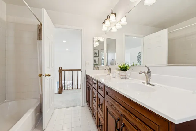 a bathroom with a sink a large mirror and a bathtub with shower