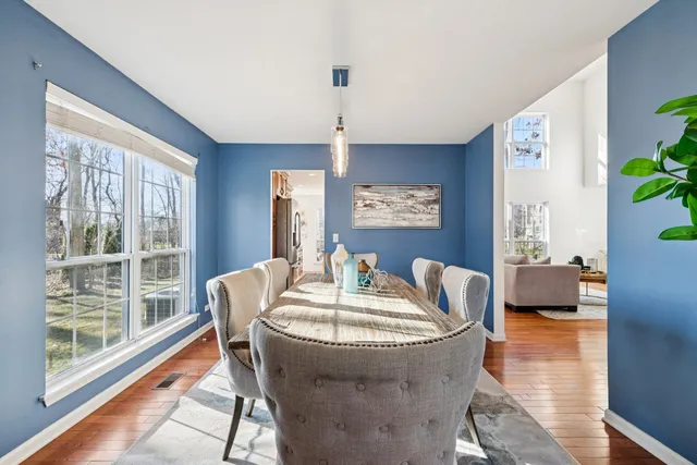 a dining room with furniture a chandelier and wooden floor