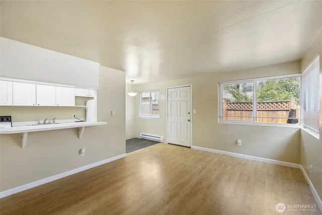 a view of a kitchen with wooden floor and electronic appliances