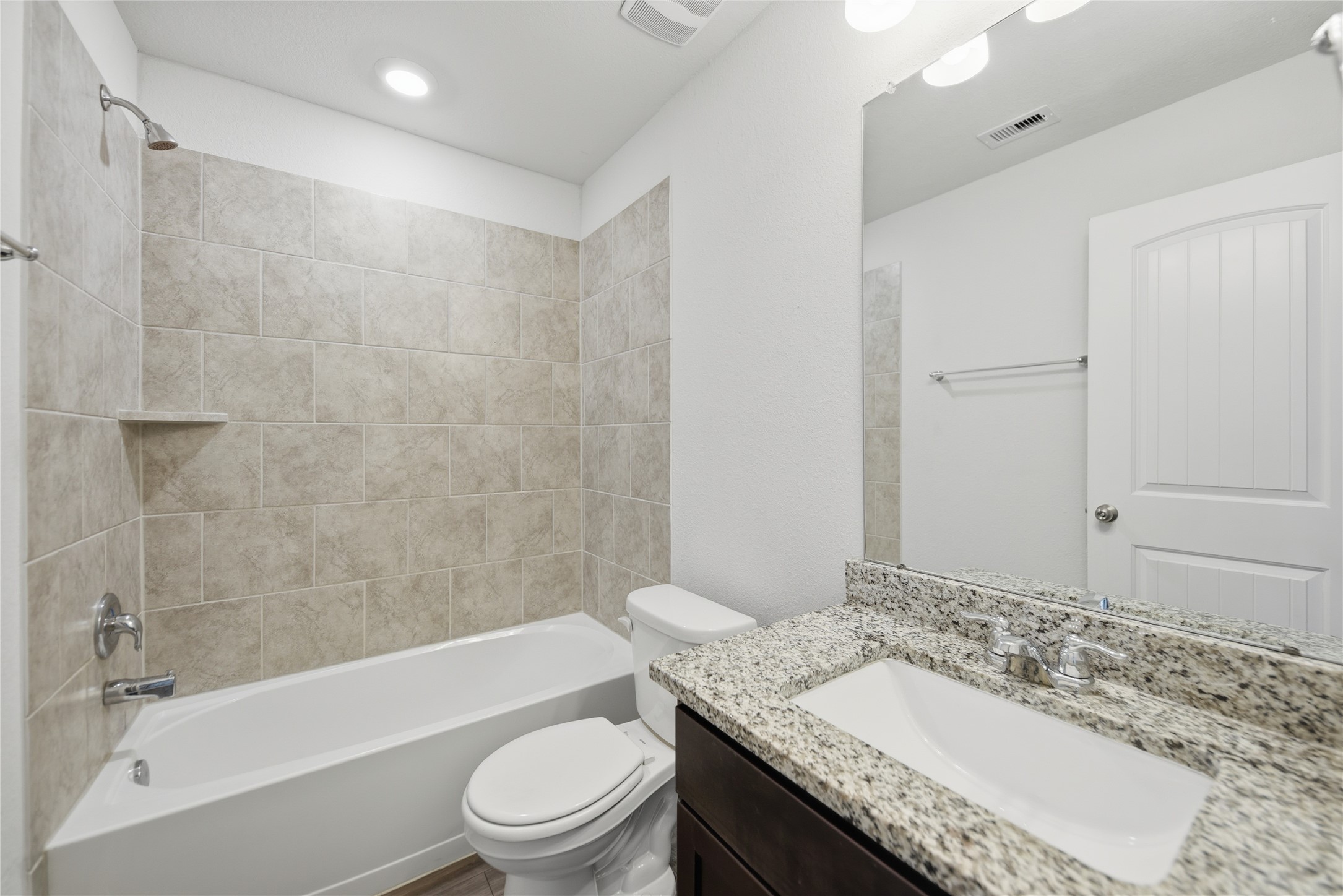 1010 Fannin Street Brenham, TX 77833 - Photo 25 of 30 a bathroom with a granite countertop sink a toilet and bathtub