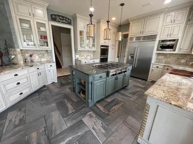 a kitchen with stainless steel appliances granite countertop a stove refrigerator and a sink