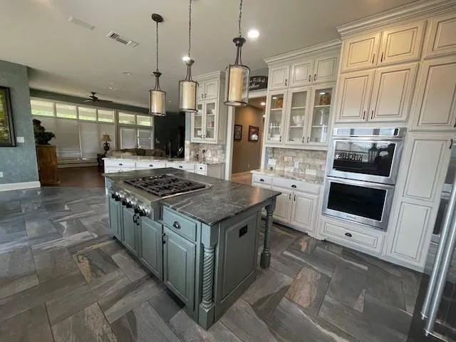 a kitchen with stainless steel appliances granite countertop a stove a sink and a refrigerator